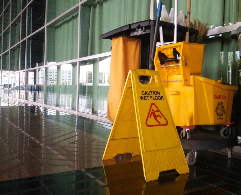 Close up view of a cleaning cart and sign