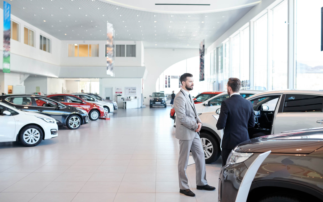 View of two car sales people at dealership