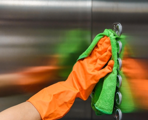 Cleaner using microfiber towel to clean elevator